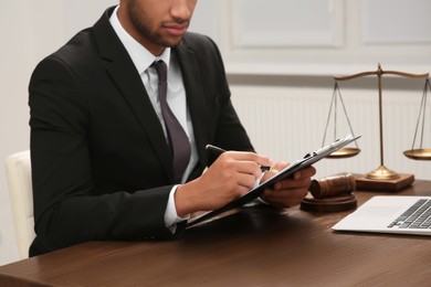 Photo of Law and justice. Lawyer working with documents at wooden table in office, closeup