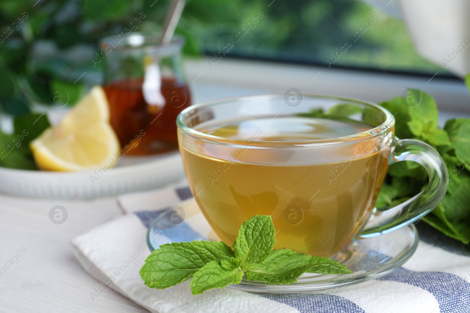 Photo of Fresh green tea with mint leaves on table