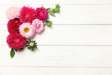 Beautiful aster flowers and space for text on wooden background, flat lay