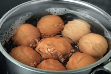 Boiling chicken eggs in saucepan, closeup view