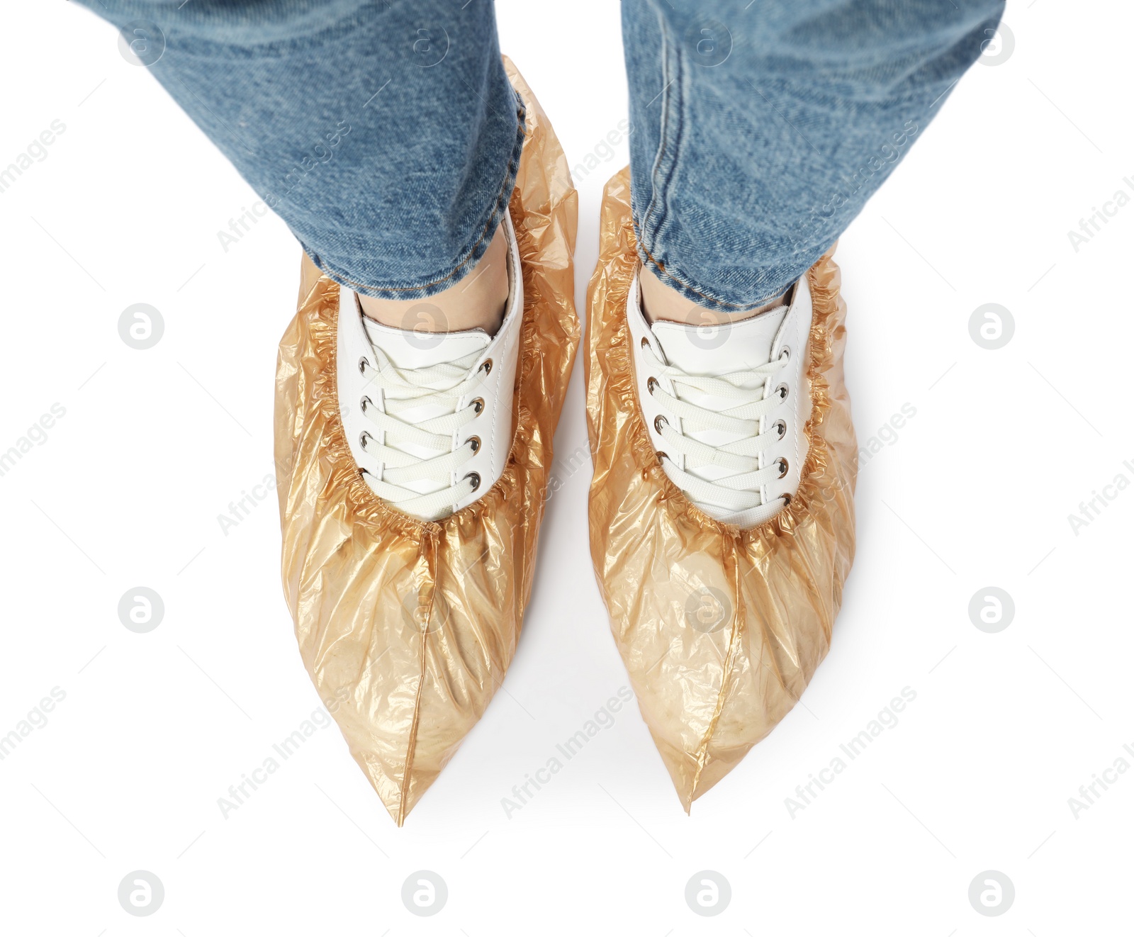 Photo of Woman wearing shoe covers onto her sneakers against white background, top view