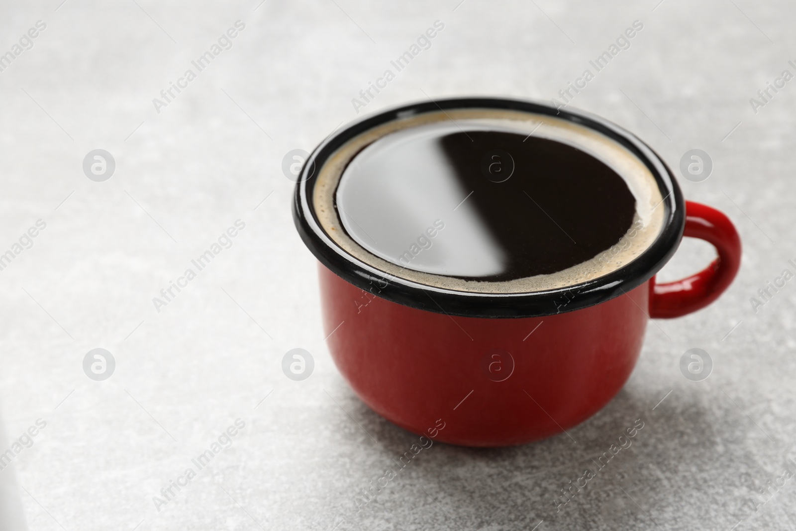 Photo of Cup of aromatic coffee on light grey table, closeup. Space for text