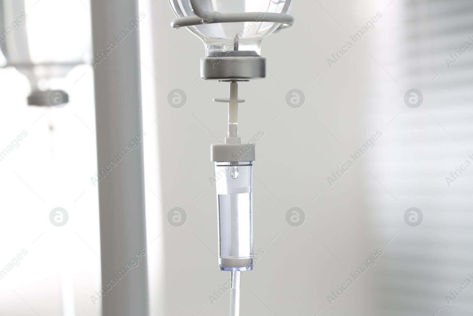 Photo of IV drip chamber against blurred light background