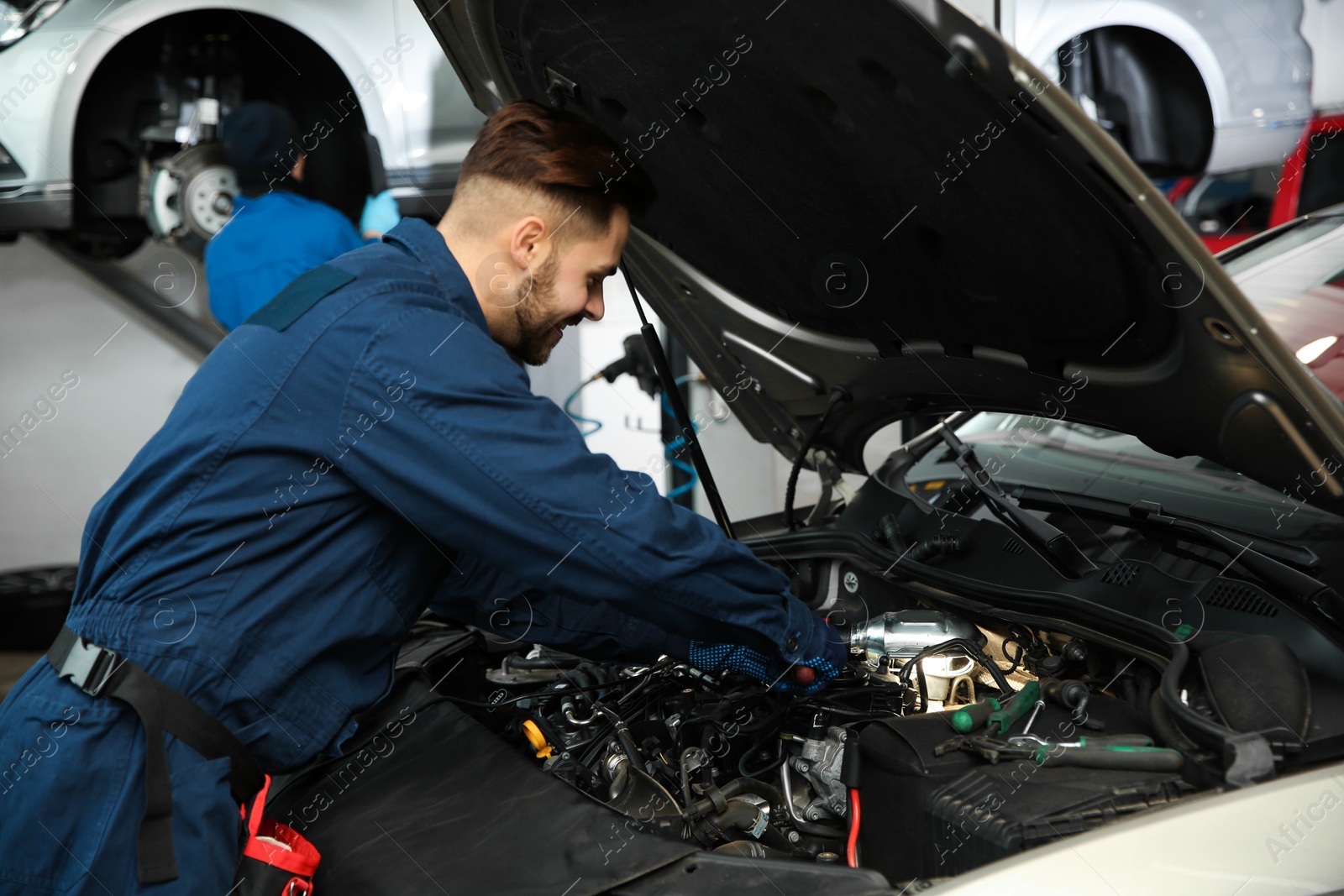 Photo of Technician checking modern car at automobile repair shop