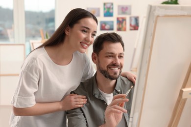 Artist teaching her student to paint in studio. Creative hobby