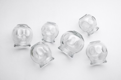 Photo of Glass cups on light grey background, flat lay. Cupping therapy