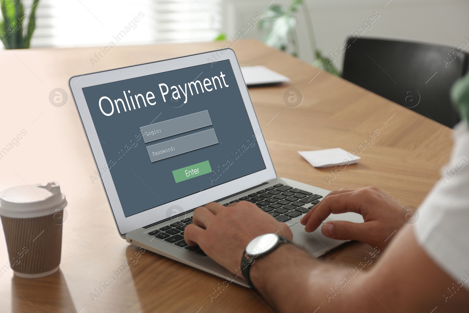 Image of Man using laptop for online payment at wooden table, closeup