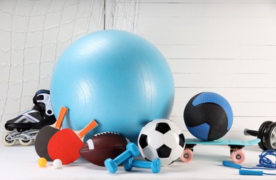 Many different sports equipment on white table