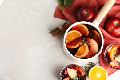 Photo of Tasty mulled wine with spices on light grey table, flat lay. Space for text