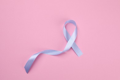 International Psoriasis Day. Ribbon as symbol of support on pink background, top view