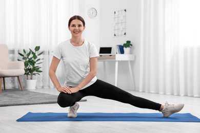 Morning routine. Happy woman doing stretching exercise at home