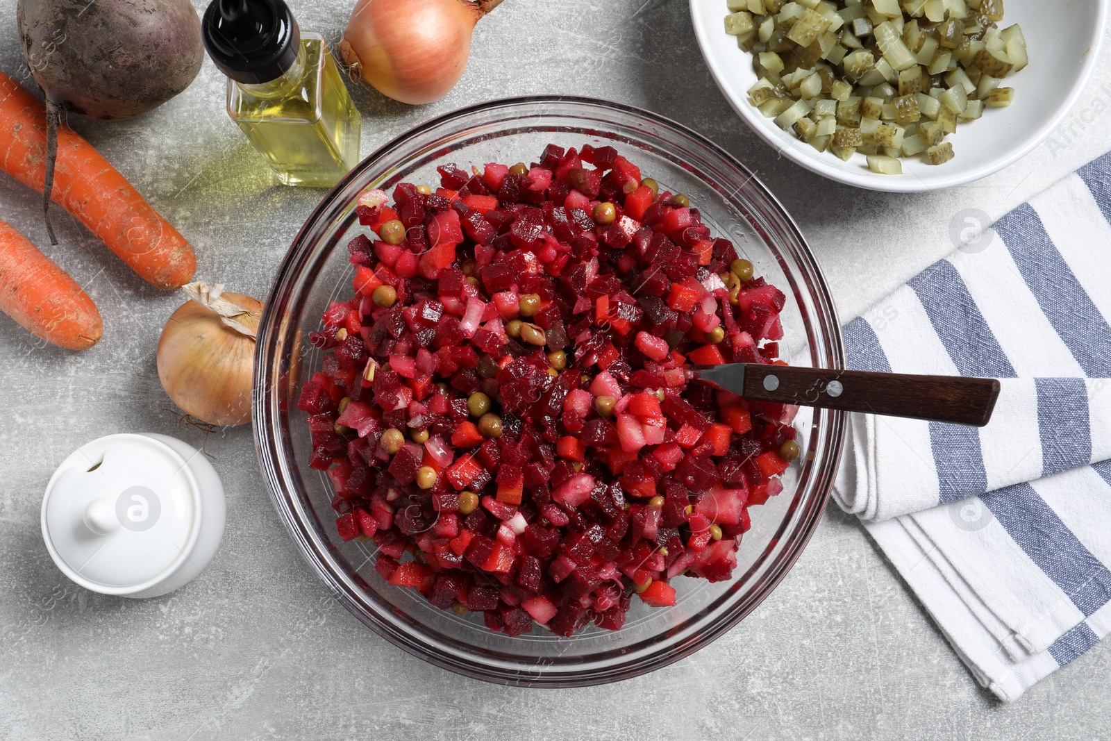 Photo of Delicious fresh vinaigrette salad and ingredients on light grey table, flat lay