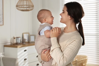 Photo of Happy young mother with her baby at home. Space for text