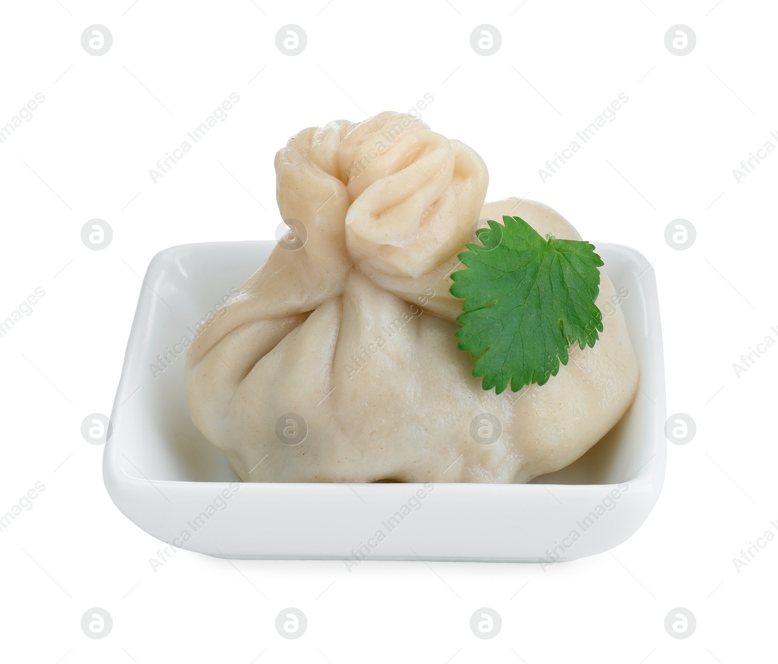 Photo of One tasty khinkali (dumpling) and parsley in bowl isolated on white. Georgian cuisine