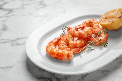 Photo of Plate with delicious fried shrimps and lemon on light background