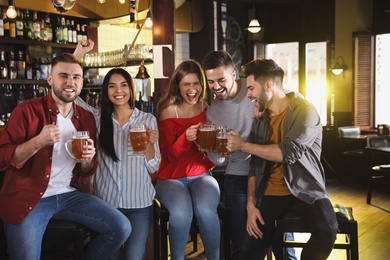 Photo of Group of friends watching football in sport bar