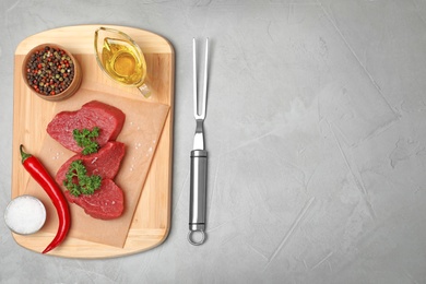 Photo of Flat lay composition with raw meat and space for text on grey background