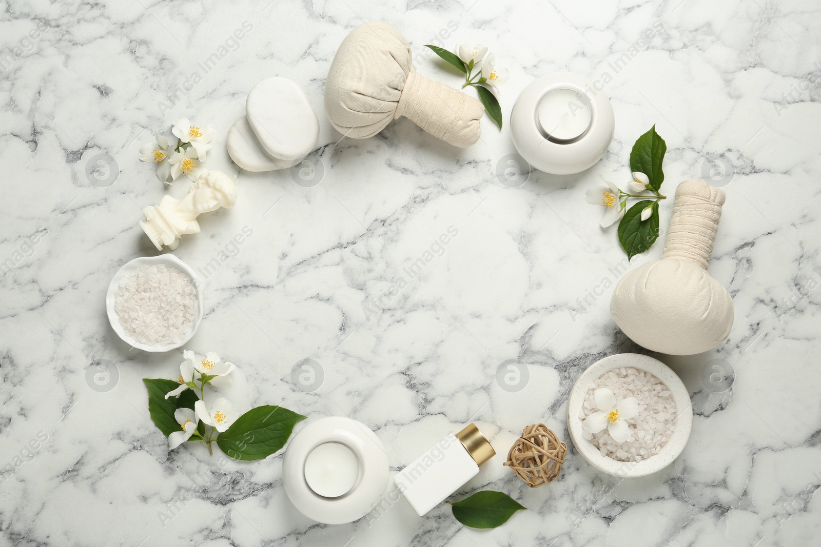 Photo of Jasmine flowers and set of spa essentials on white marble table, flat lay. Space for text