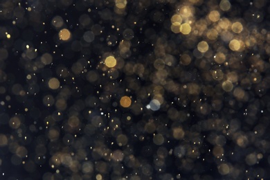 Photo of Golden glitter with bokeh effect on dark background