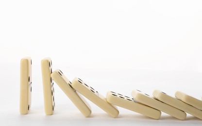 Light domino tiles falling on white background