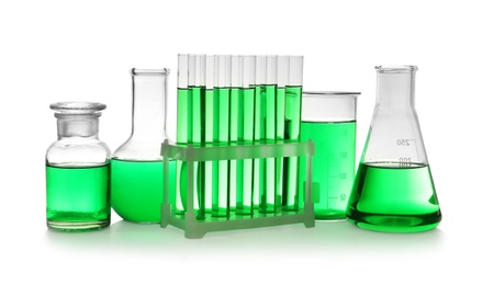 Photo of Laboratory glassware with green liquid on white background