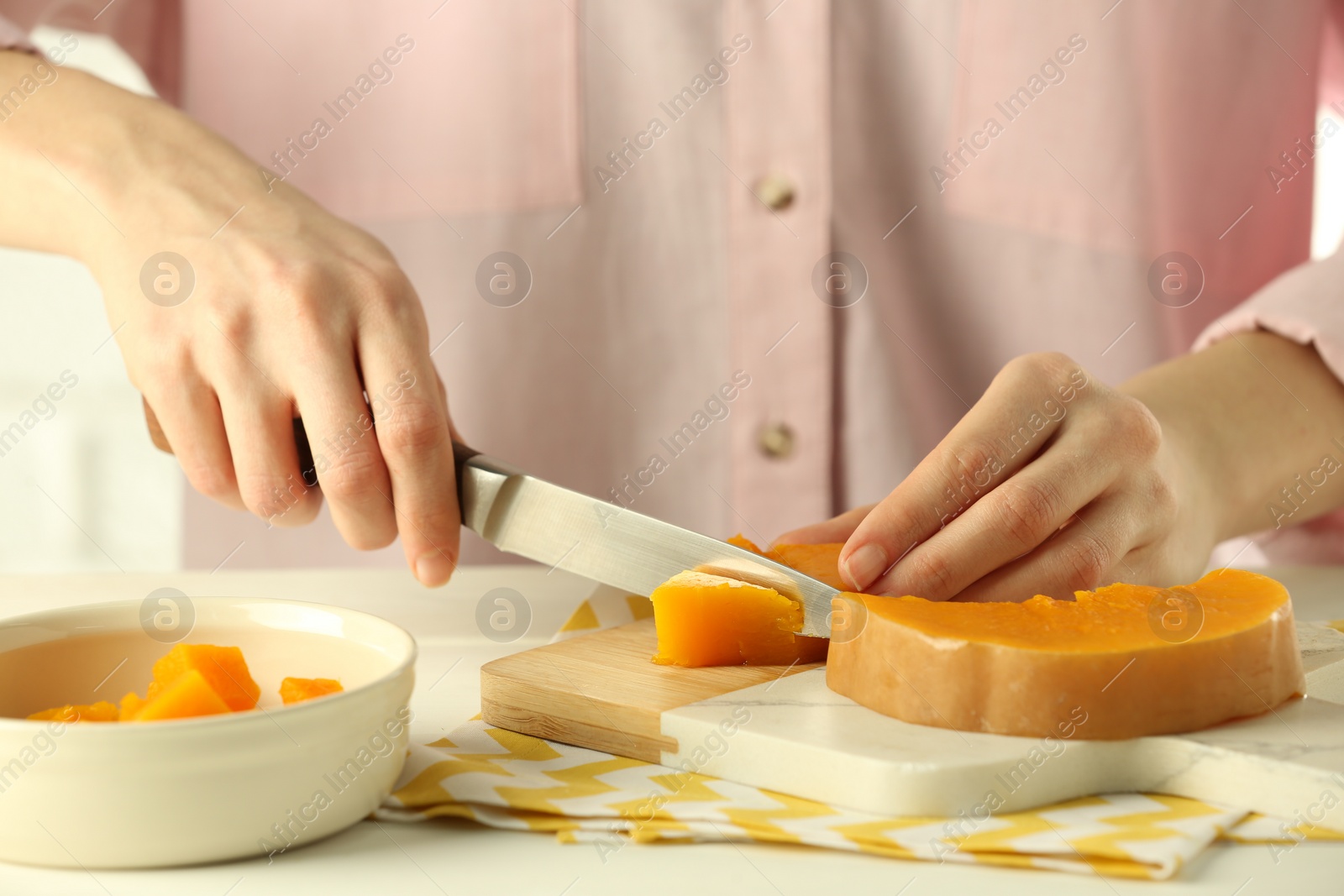 Photo of Woman cutting boiled pumpkin at table, closeup. Child's food