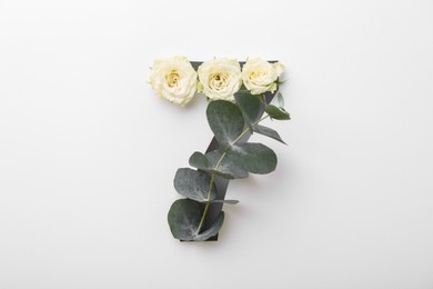 Number 7 made of beautiful flowers and eucalyptus leaves on white background, top view