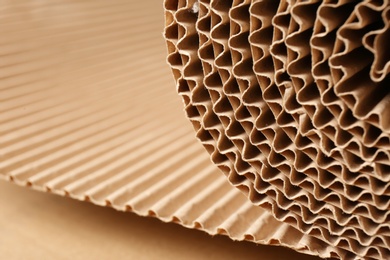 Photo of Closeup view of roll of brown corrugated cardboard, space for text. Recyclable material