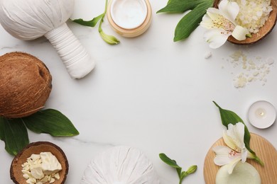 Frame made of different cosmetic products on white marble table, flat lay and space for text. Spa composition