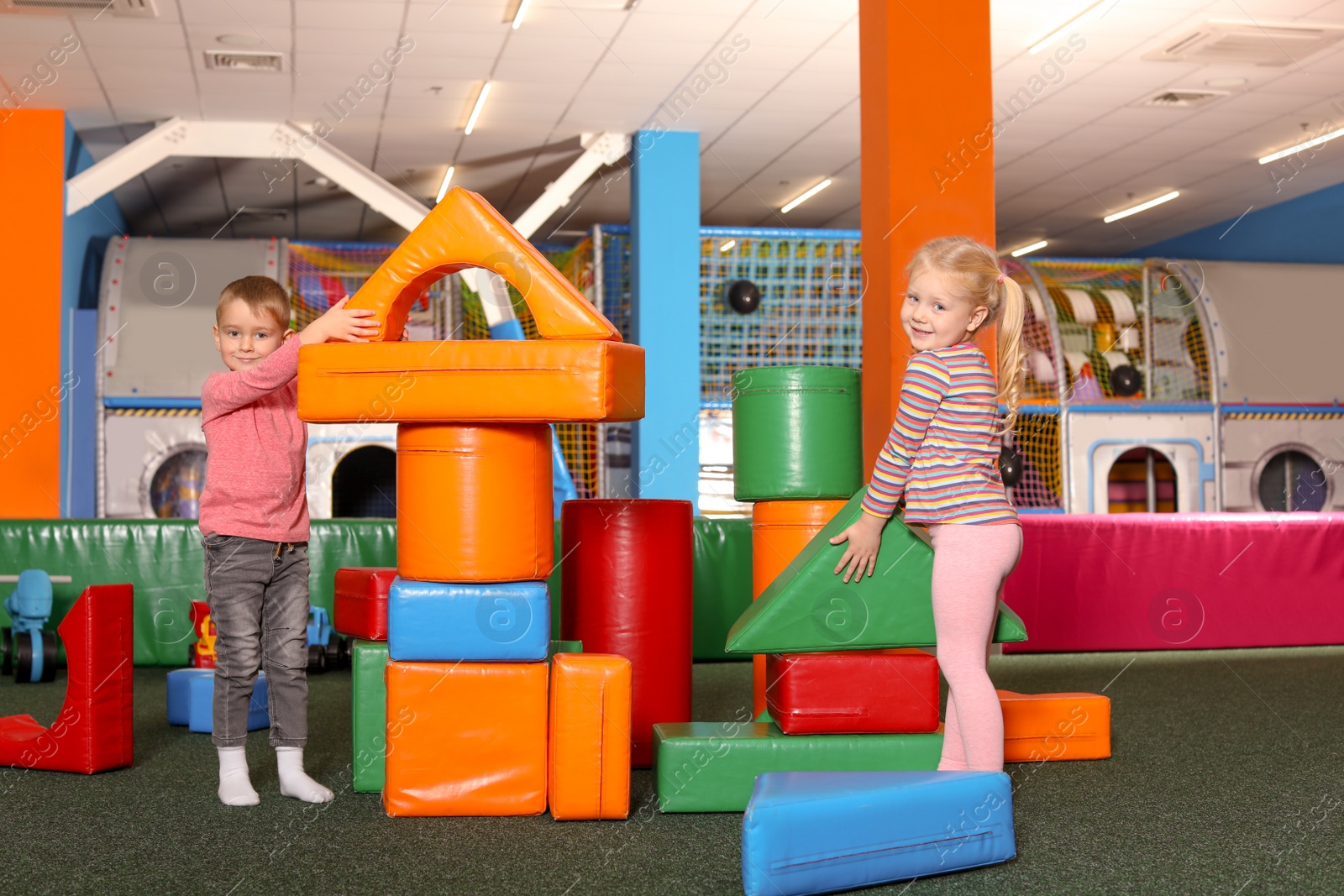 Photo of Cute children playing with colorful building blocks indoors