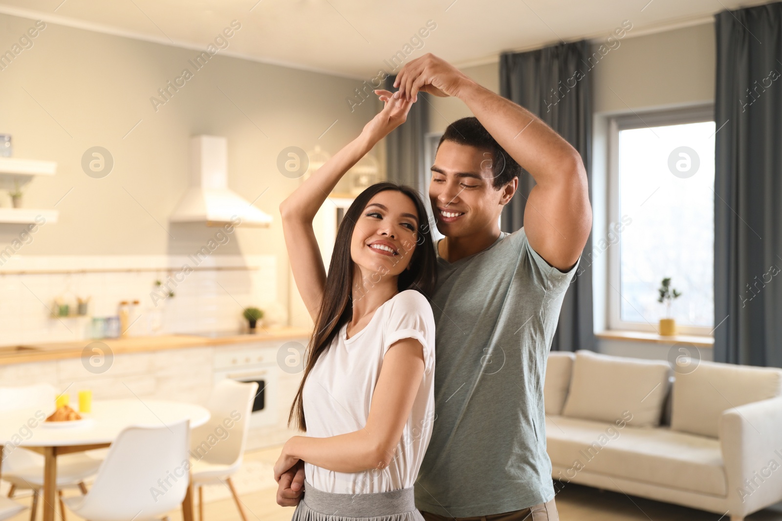 Photo of Lovely young interracial couple dancing at home