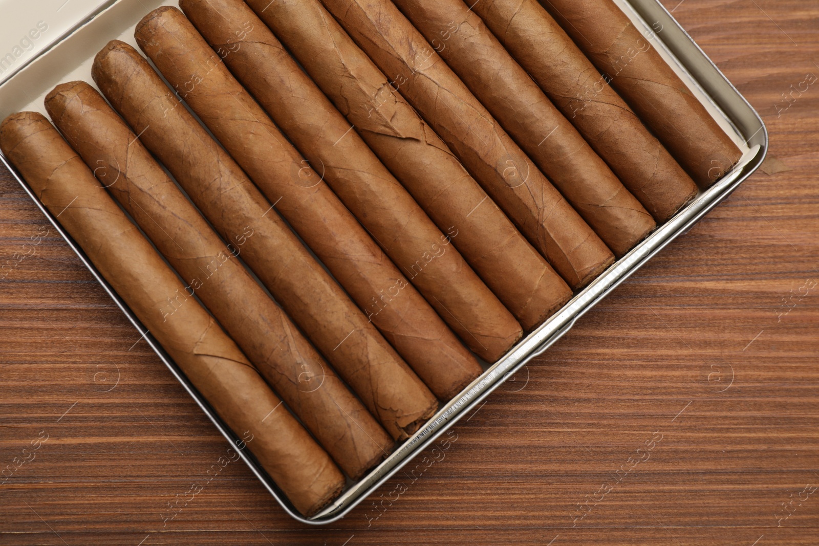 Photo of Box with expensive cigars on wooden table, top view