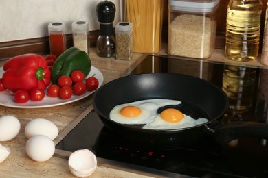 Photo of Cooking eggs for breakfast in frying pan on cooktop