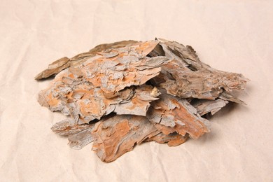Photo of Tree bark pieces on beige crumpled paper