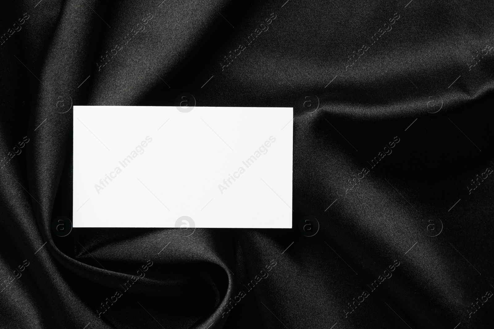 Photo of Blank business card on black fabric, top view. Mockup for design