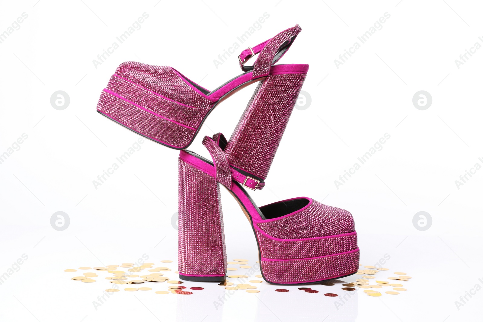 Photo of Fashionable punk square toe ankle strap pumps and confetti isolated on white. Shiny party platform high heeled shoes