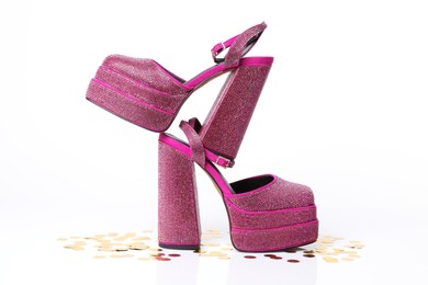 Fashionable punk square toe ankle strap pumps and confetti isolated on white. Shiny party platform high heeled shoes