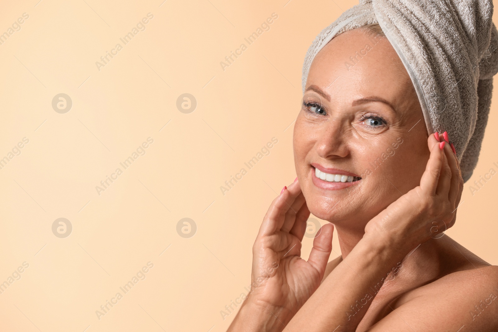 Photo of Portrait of beautiful mature woman with perfect skin on beige background. Space for text