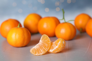 Photo of Segments of fresh ripe tangerine on grey table