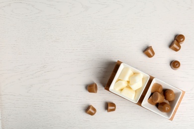 Flat lay composition with milk and coffee ice cubes on white wooden background. Space for text