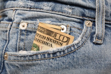 Photo of Dollar banknote in pocket of jeans, closeup. Spending money