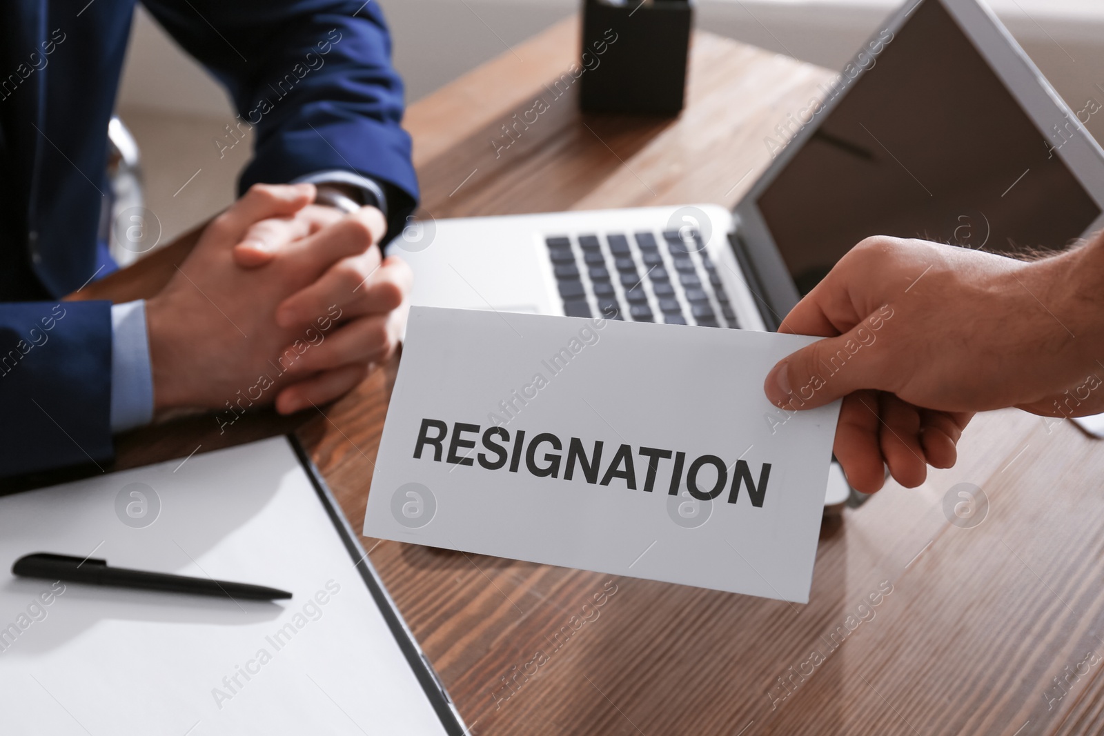 Photo of Employee giving resignation letter to boss in office, closeup