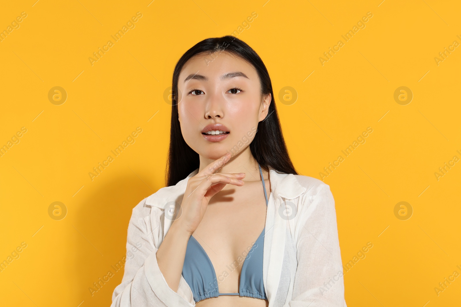 Photo of Beautiful young woman with makeup on orange background