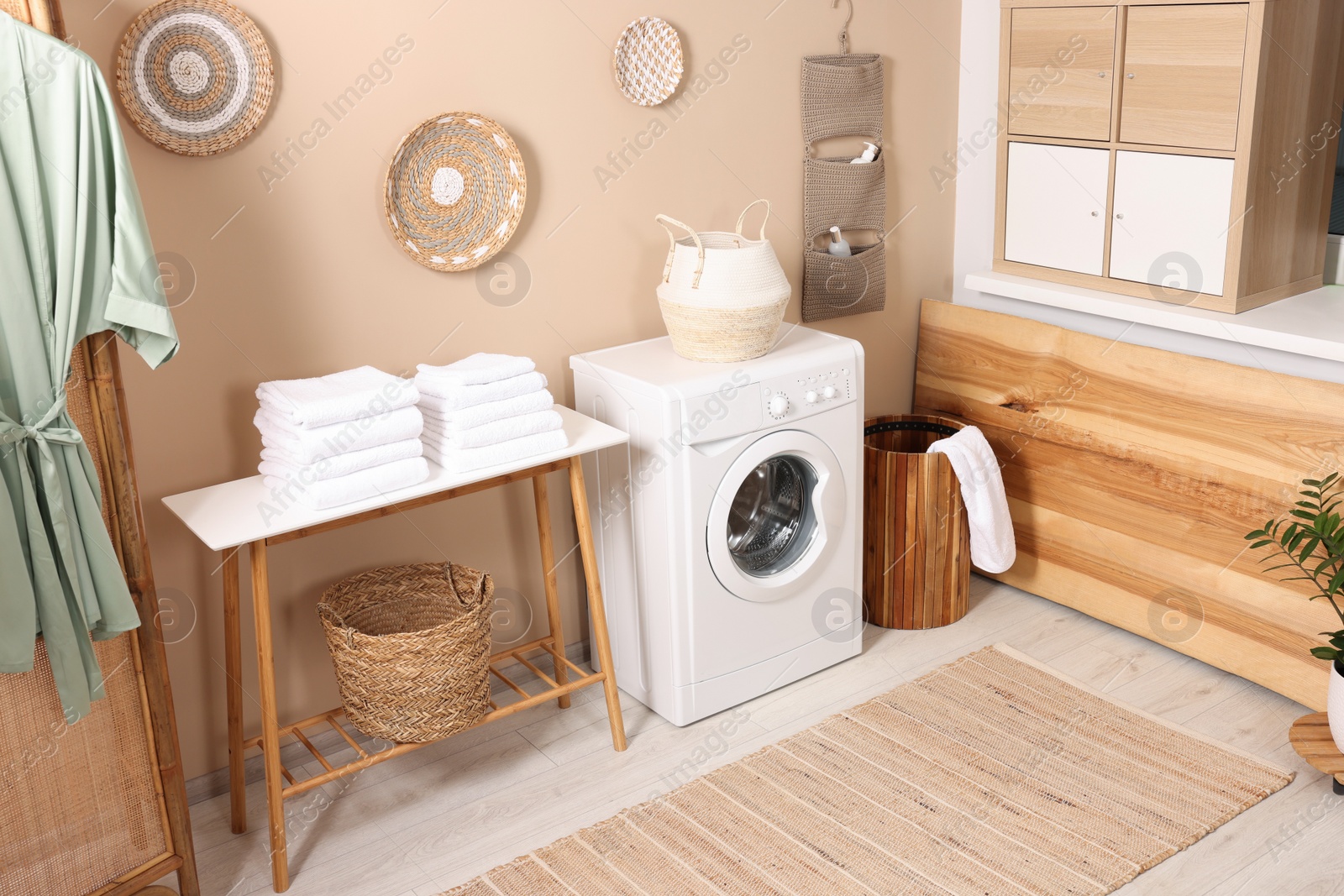 Photo of Stylish laundry room with modern washing machine. Interior design