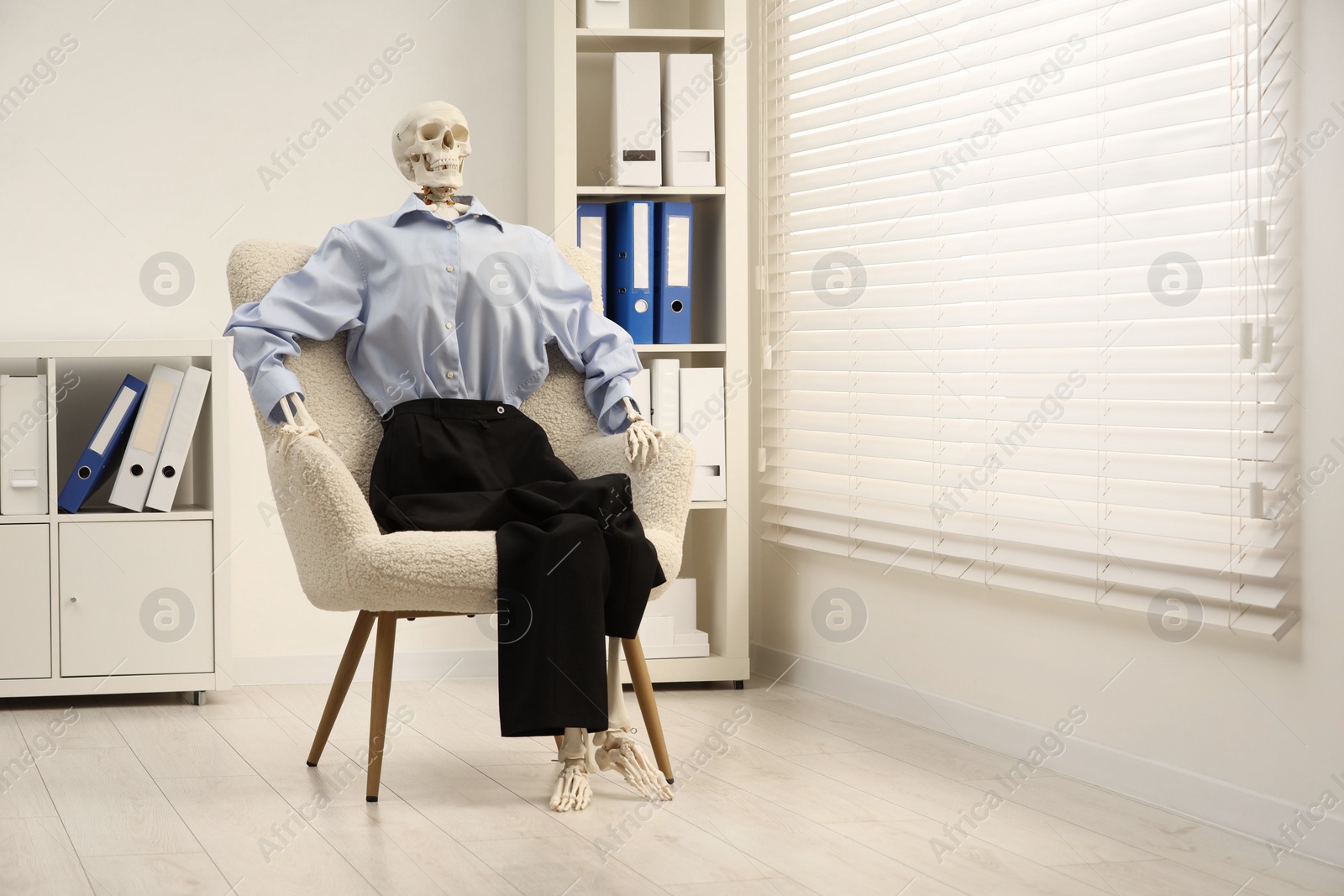 Photo of Waiting concept. Human skeleton sitting in armchair at office, space for text