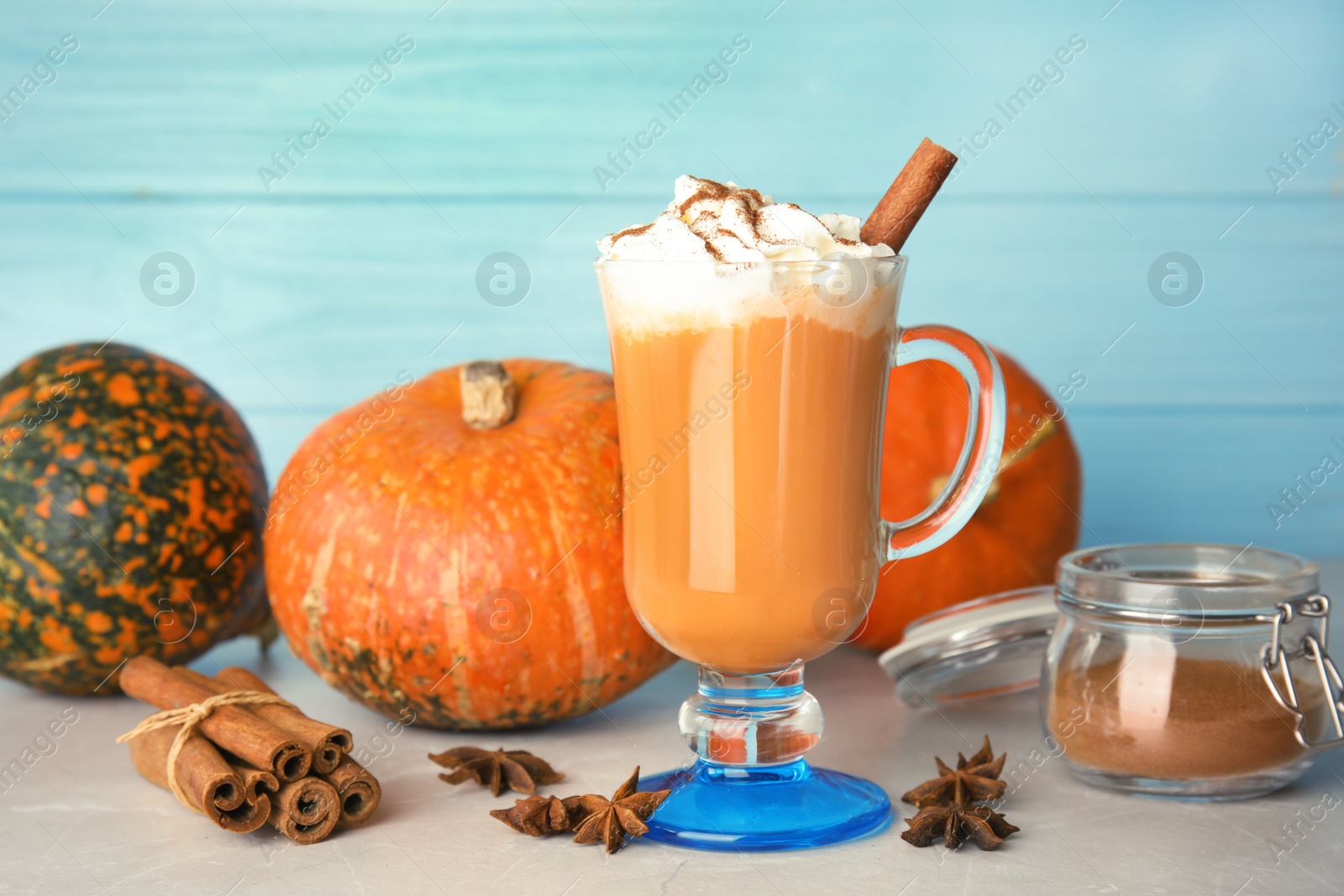 Photo of Composition with tasty pumpkin spice latte on table