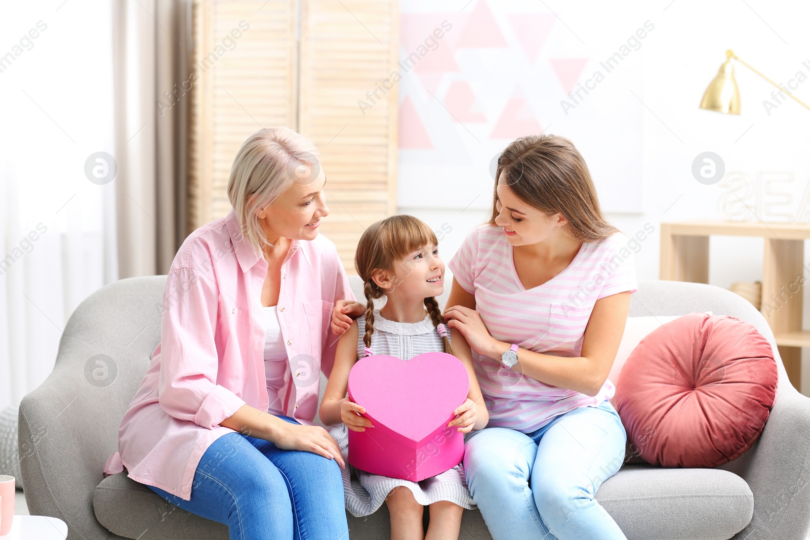 Photo of Beautiful mature lady, daughter and grandchild with gift box at home. Happy Women's Day