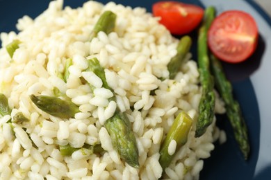 Photo of Delicious risotto with asparagus and tomatoes, closeup