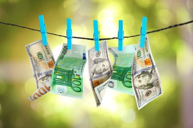 Image of Money laundering. Banknotes hanging on clothesline outdoors
