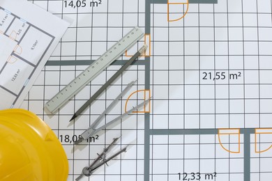 Construction drawings, safety hat and stationery, flat lay